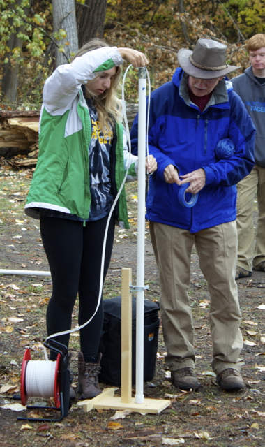 Dr. Bill Woessner assists a student with a water level measurement.