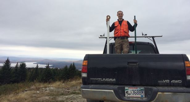 Alexej on top of his truck, ready to go set up a snow measuring stake at a camera trap in the CT Lakes Natural Area, NH