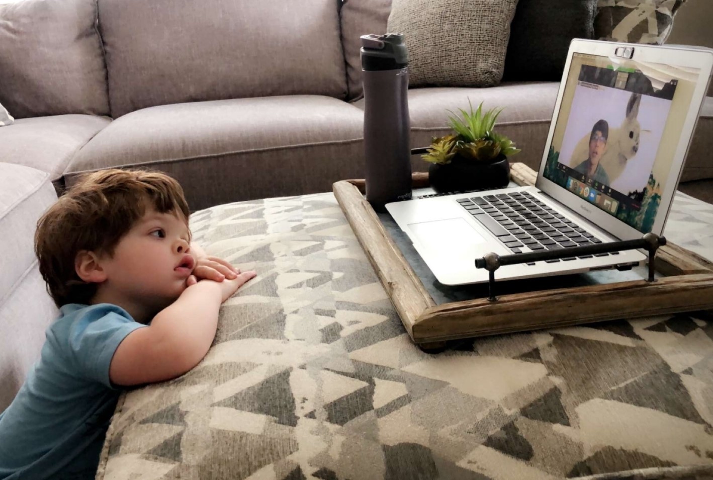 A toddler watching the presentation via laptop