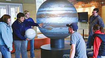 Martin Horejsi, an associate professor in the Department of Curriculum and Instruction, discusses celestial objects using the 5-foot-wide OmniGlobe as a teaching tool. (Photo by Jonathan Crummett)