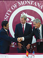 Vietnamese Ambassador Le Cong Phung shakes hands with President Dennison while U.S. Sen. Max Baucus looks on.