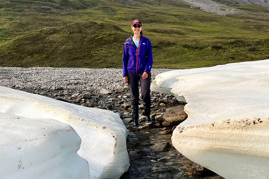 A picture of Anna Klene standing between two melting chunks of ice.