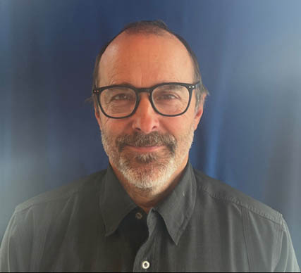 Portrait shot of Dave McEvoy wearing black glasses with a salt and pepper beard