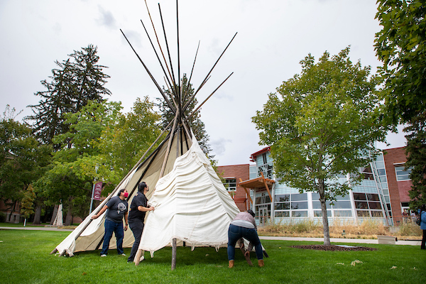 Assembling a tee pee in 1/4 of the oval near the Payne Native American Center.