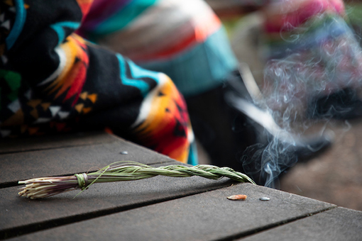 Burning of sage with Pendleton coat in the background