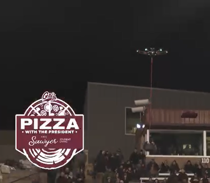 a drone carries a box of pizzas across the Washington Grizzly stadium during a football game