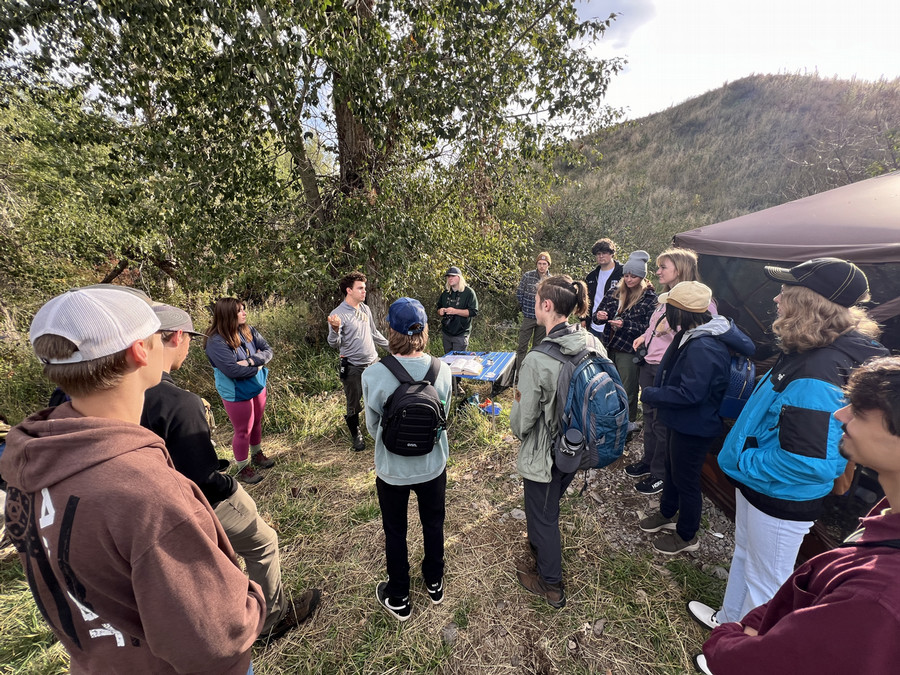 A group of students from the University of Montana gather around the banding table in the fall. 