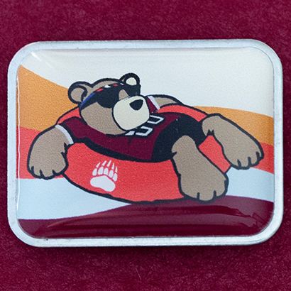 The Freshman Float pin depicts a bear floating down the river in an inner tube.