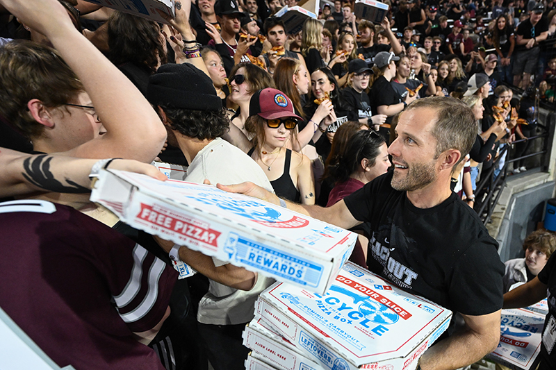 President Bodnar hands out pizzas during a football game