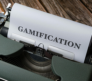 The word "Gamification" is displayed above a typewriter. 