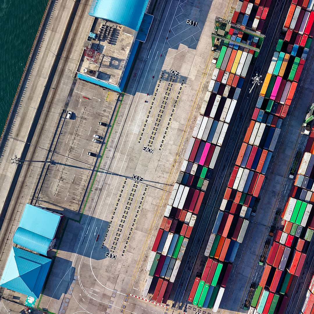 top down view of shipping containers in a port with other buildings