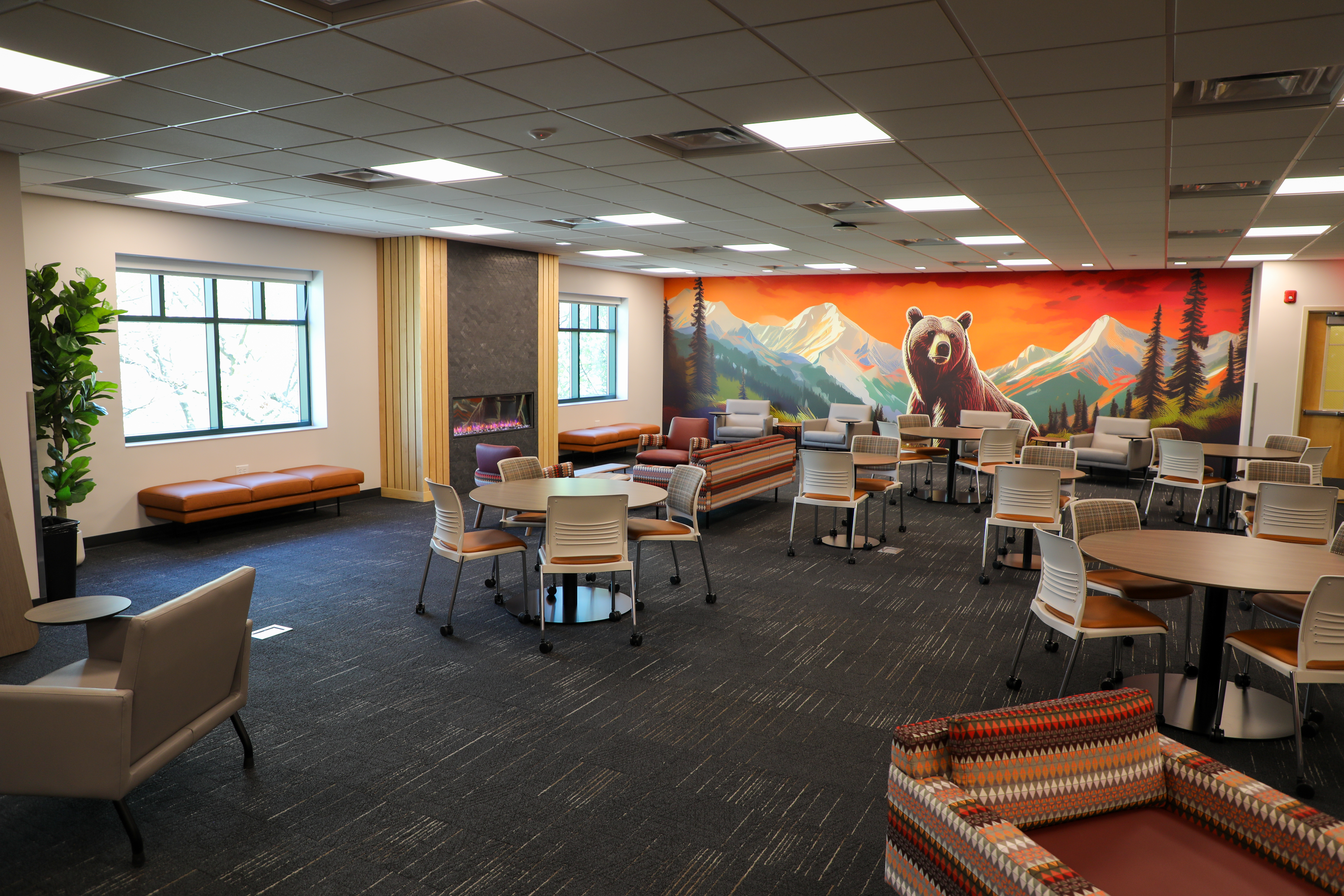 Main gathering space in The DEN. Seating and tables throughout the space.