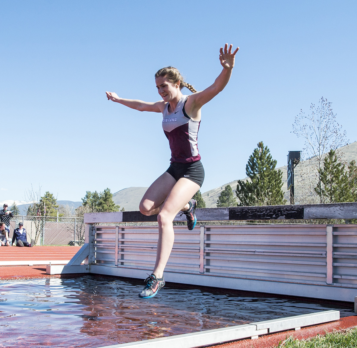 Runner jumping over steeplechase obstacle