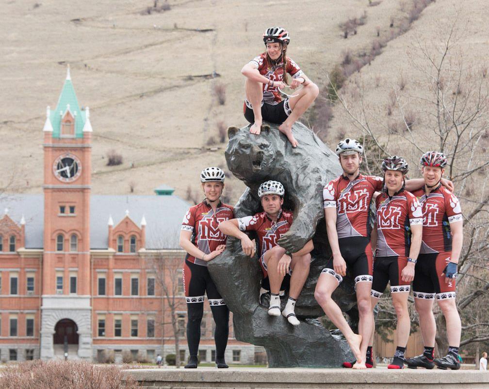 Cycling team posing around the Grizzly Bear Statue