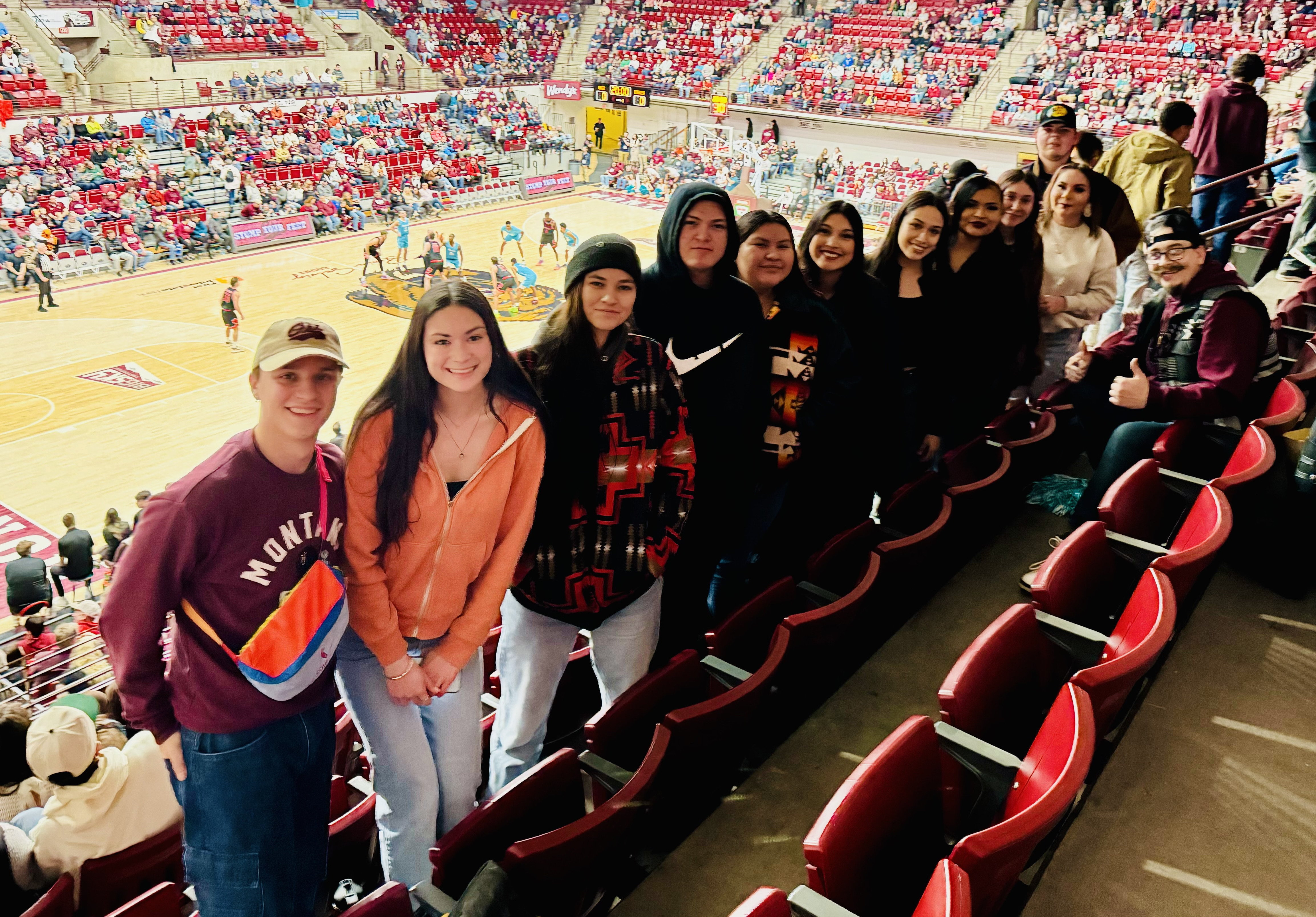 Students posed in front of basketball game at the University of Montana