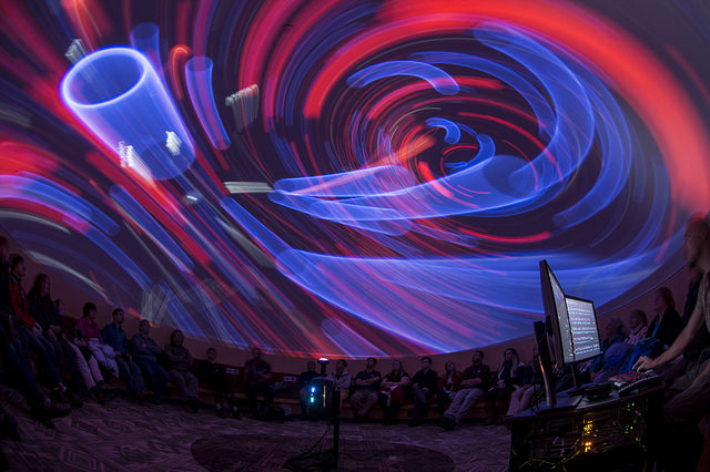 red and blue shapes spiraling around on the ceiling of a planetarium