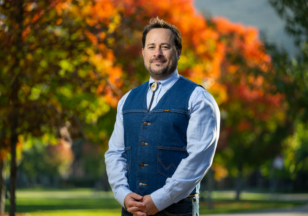 Fernando Sanchez standing outside with autumn colored trees in the background