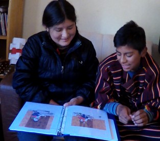 two people looking at a notebook together and talking