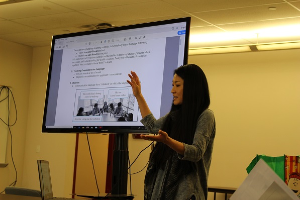 mizuki miyashita standing in front of a projection screen teaching