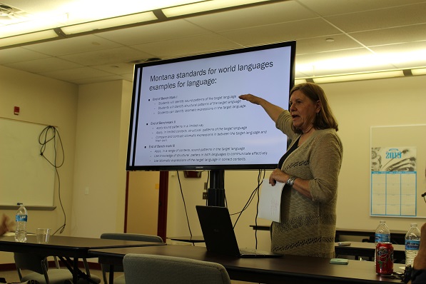 susan penfield pointing at a projection screen while teaching in front of a classroom