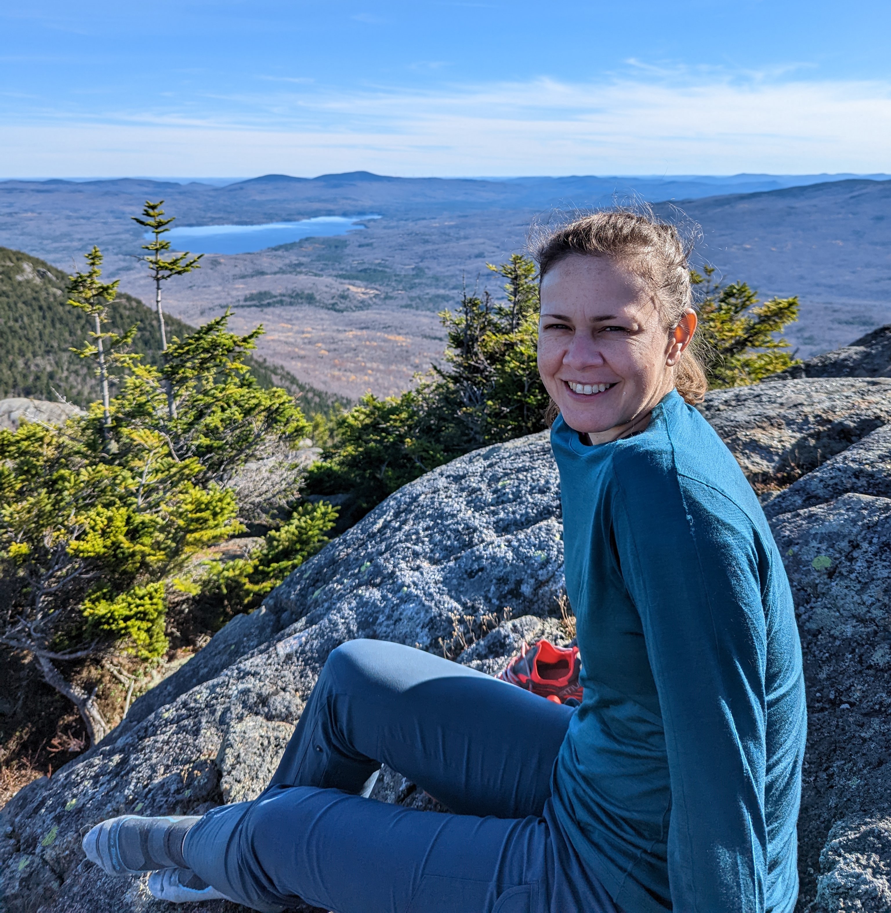 Erica Reider sitting on a rock cliff before a body of water