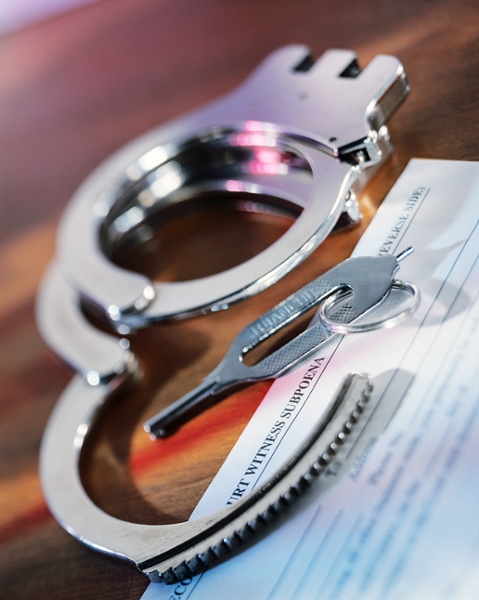 Handcuffs and a key resting on top of a legal document.