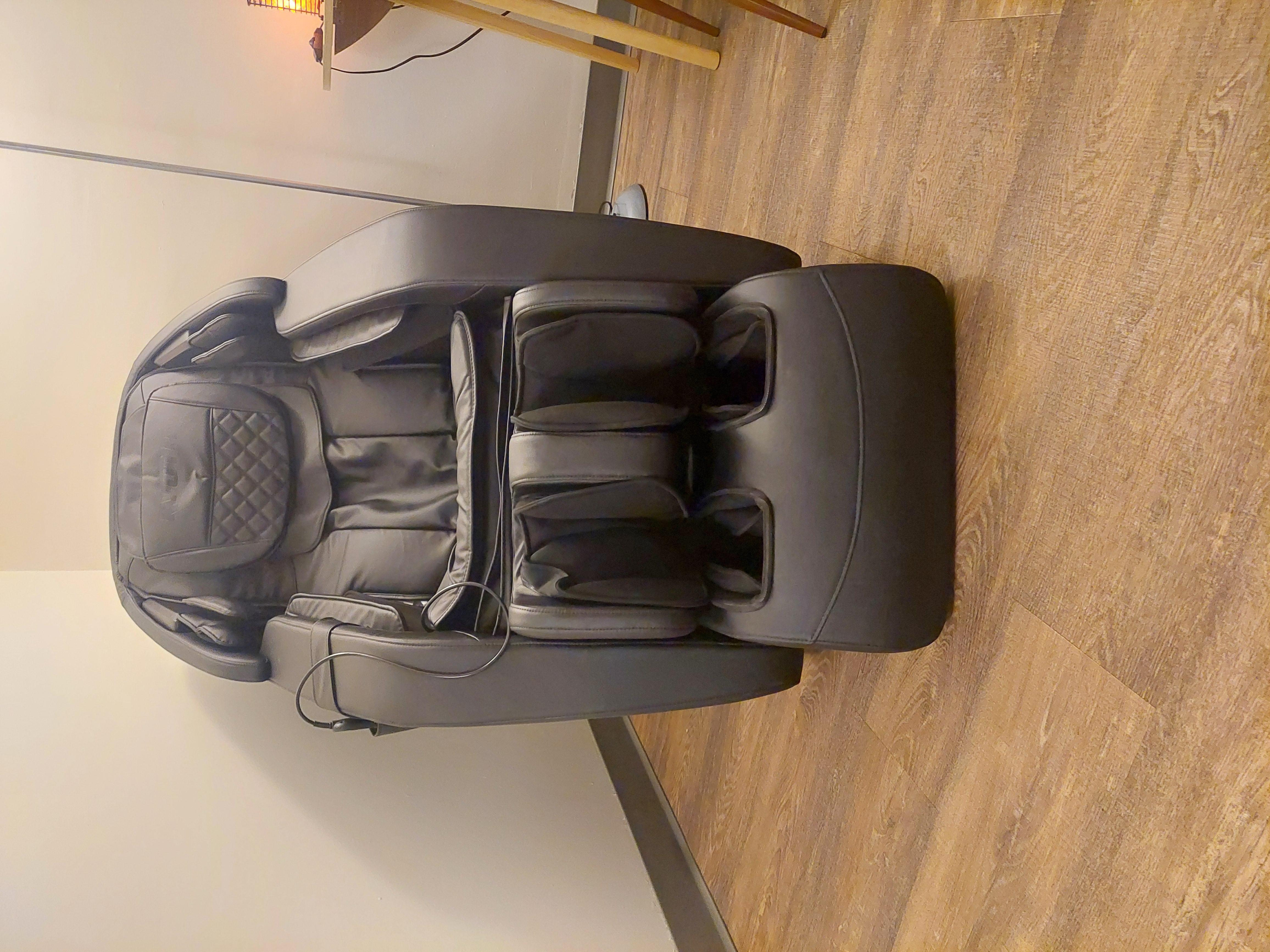a massage chair in a wooden floored room