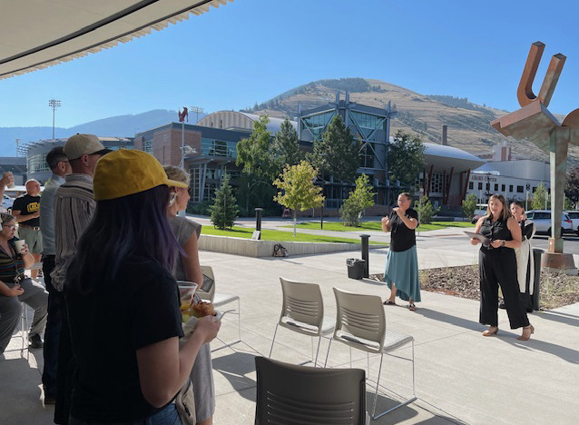 Jessica Weltman, UM's ADA Coordinator. and Charity Atteberry, the ODE Director, with sign language interpreter Brandy Reinhart, stand in front of attendees as Weltman delivers her speech.