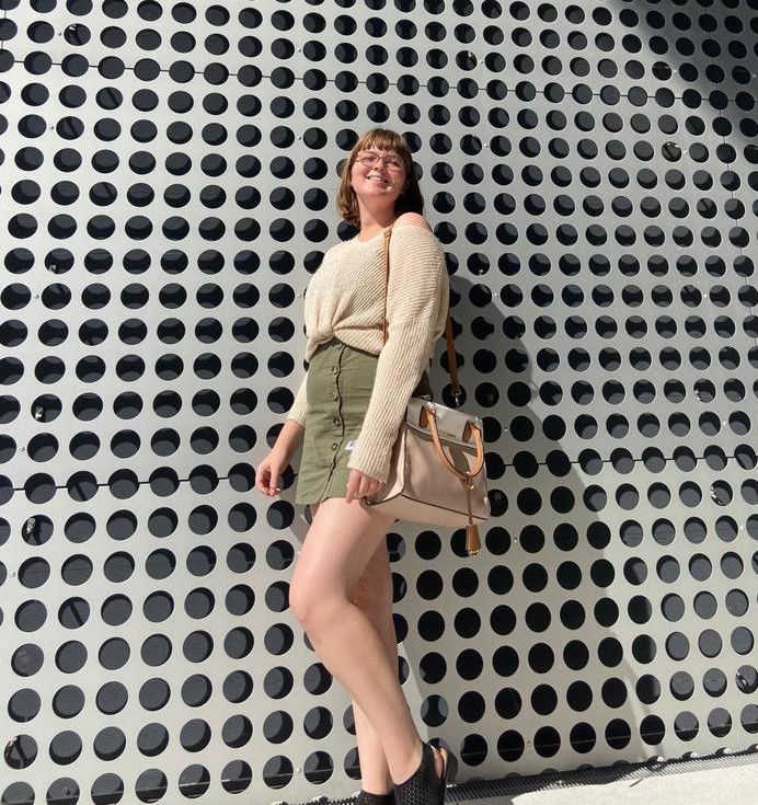 Sarah Attaway posing in front of circle covered wall