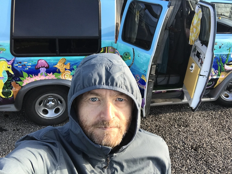 Devin Hayes in front of a car with fish painted on it