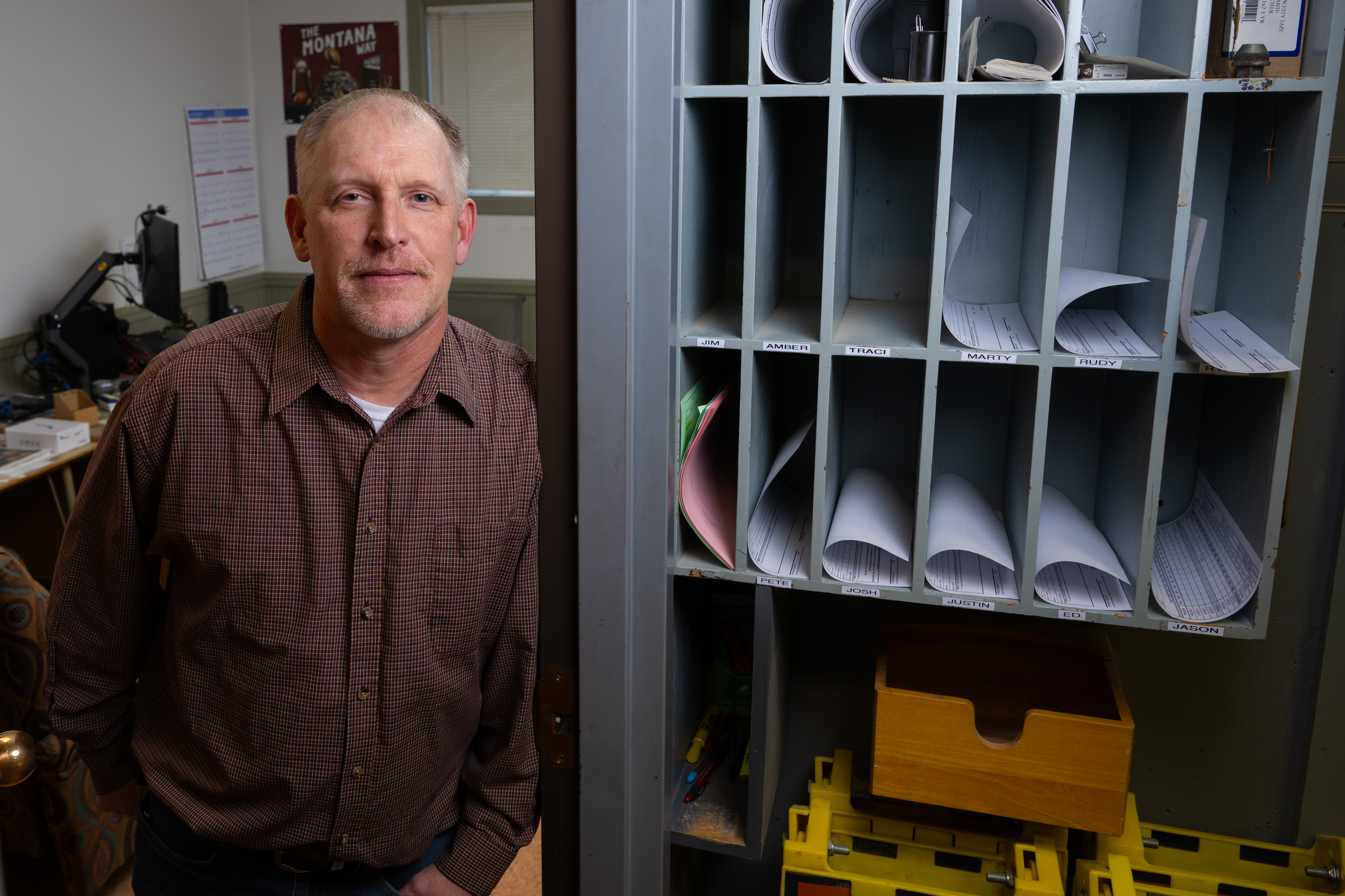 Shawn Monson stands near office mailboxes.