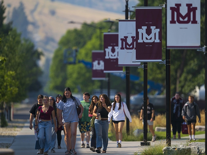 Students walking on campus with banners on poles