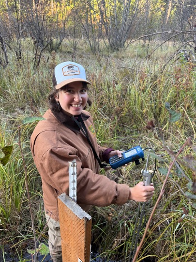 Hannah Halverson smiling with hydrology field device