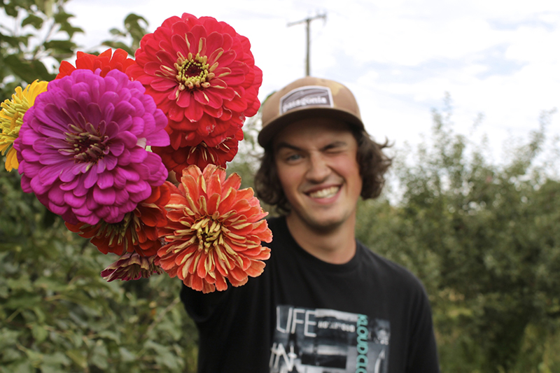 student with bunch of zinia flowers