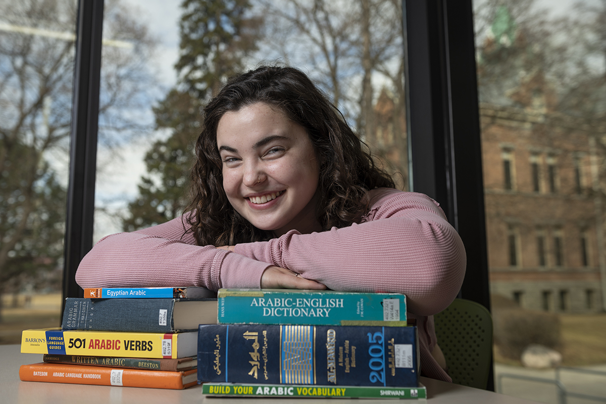 cana odegaard rests on stack of books