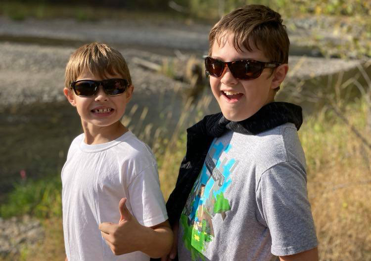 Two boys wearing sunglasses and smiling