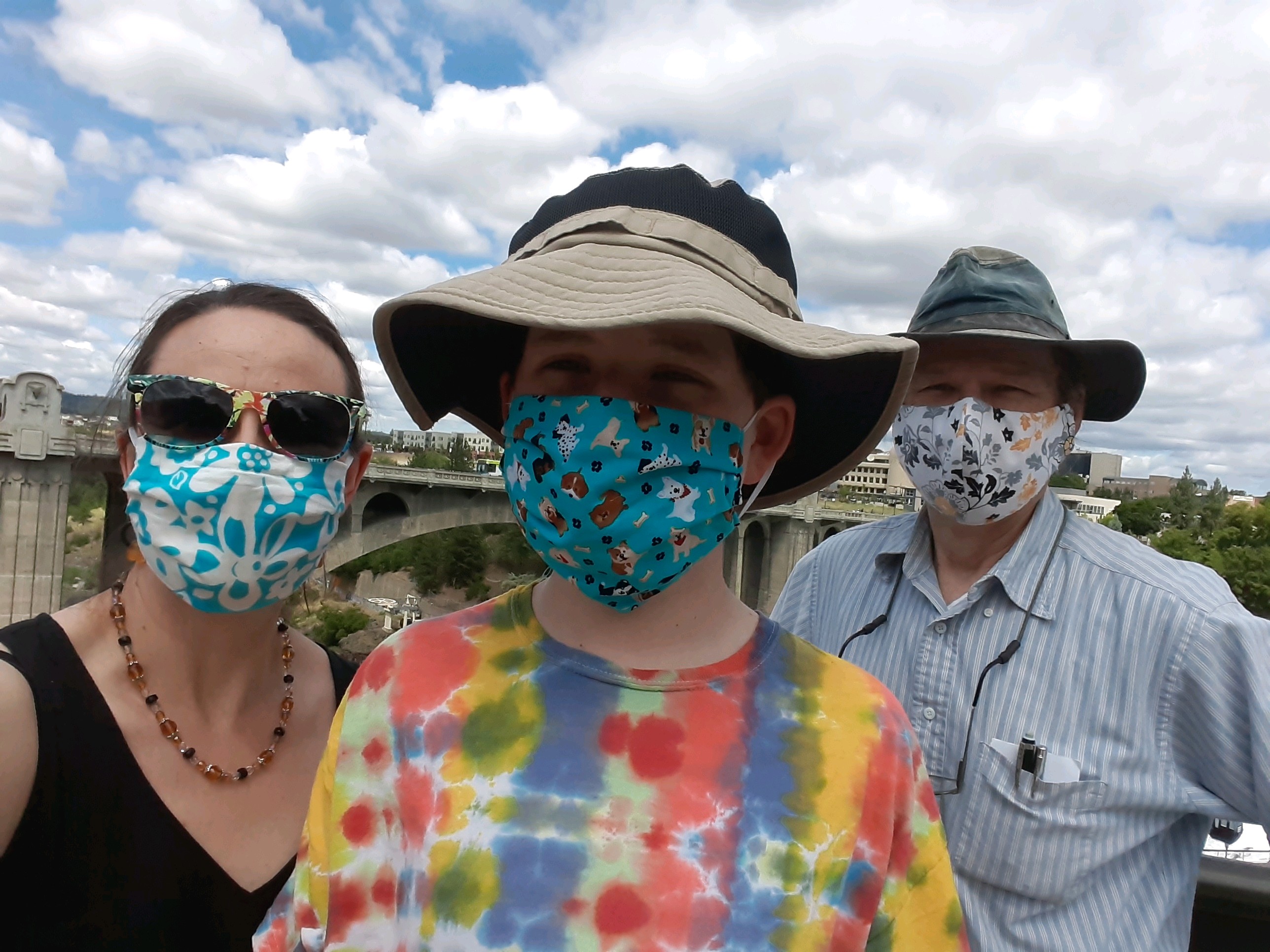 a boy with his parents all wearing masks 