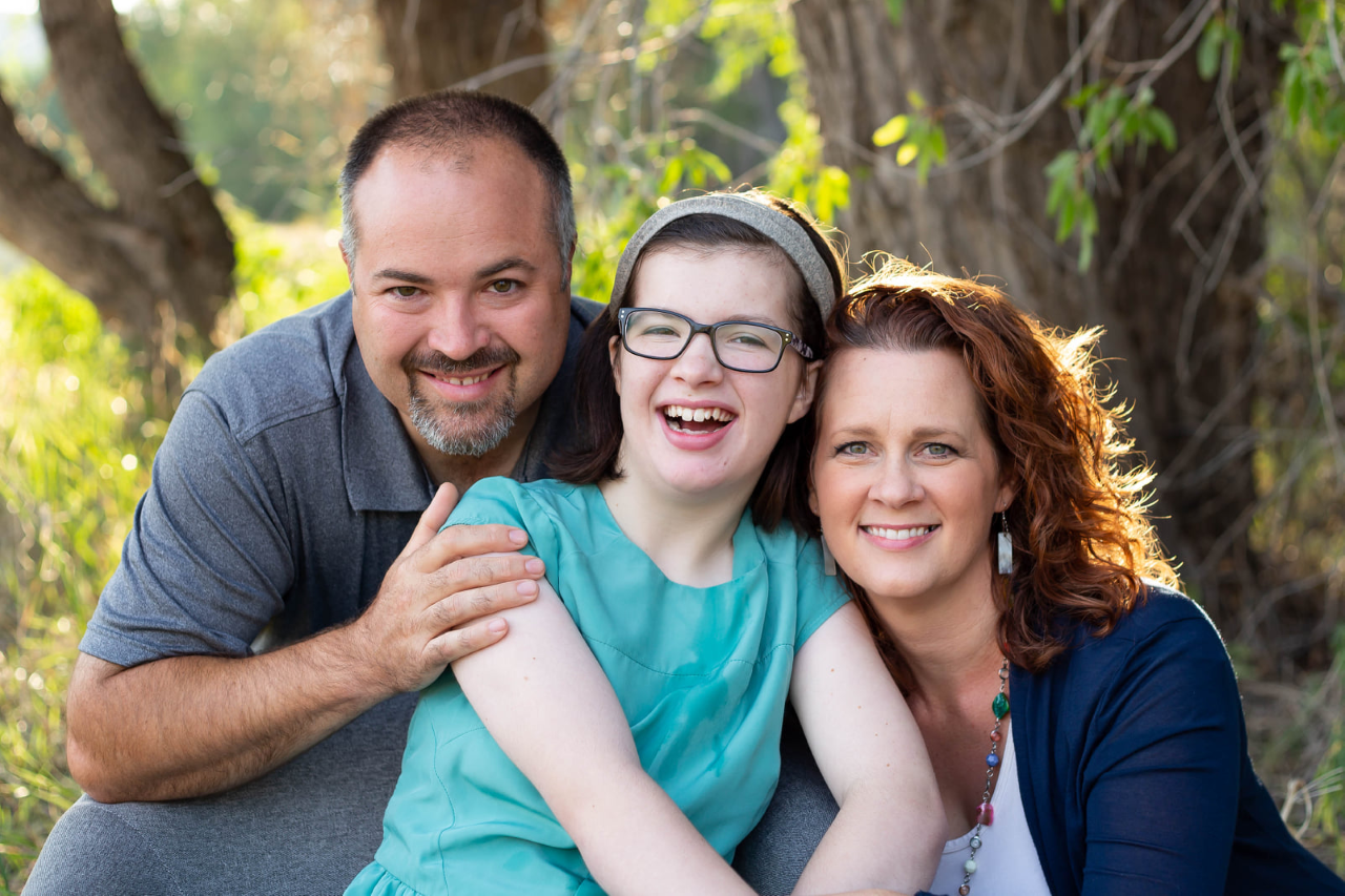 A girl with her parents all smiling