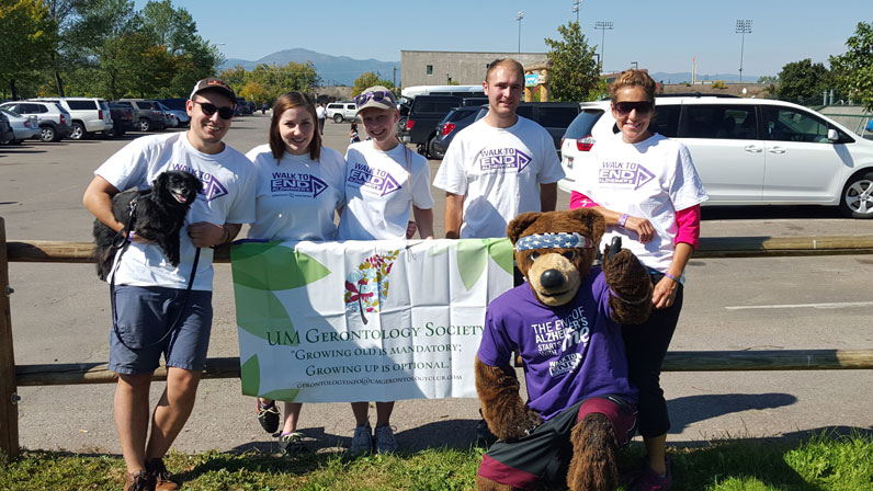UMGS members and Monte the bear with UM Gerontology Society banner