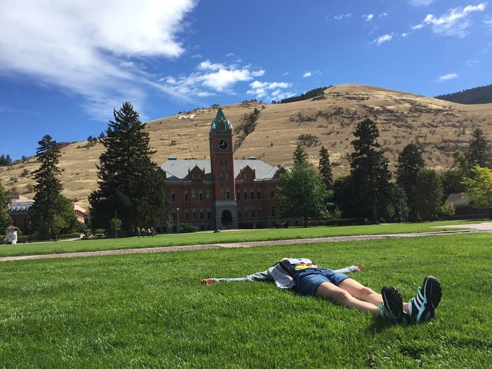 A student laying on the oval
