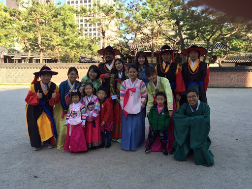 A student standing with a group in traditional Korean garb