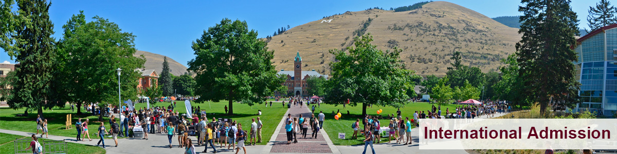 view of UM Main Hall in the summer with students walking 