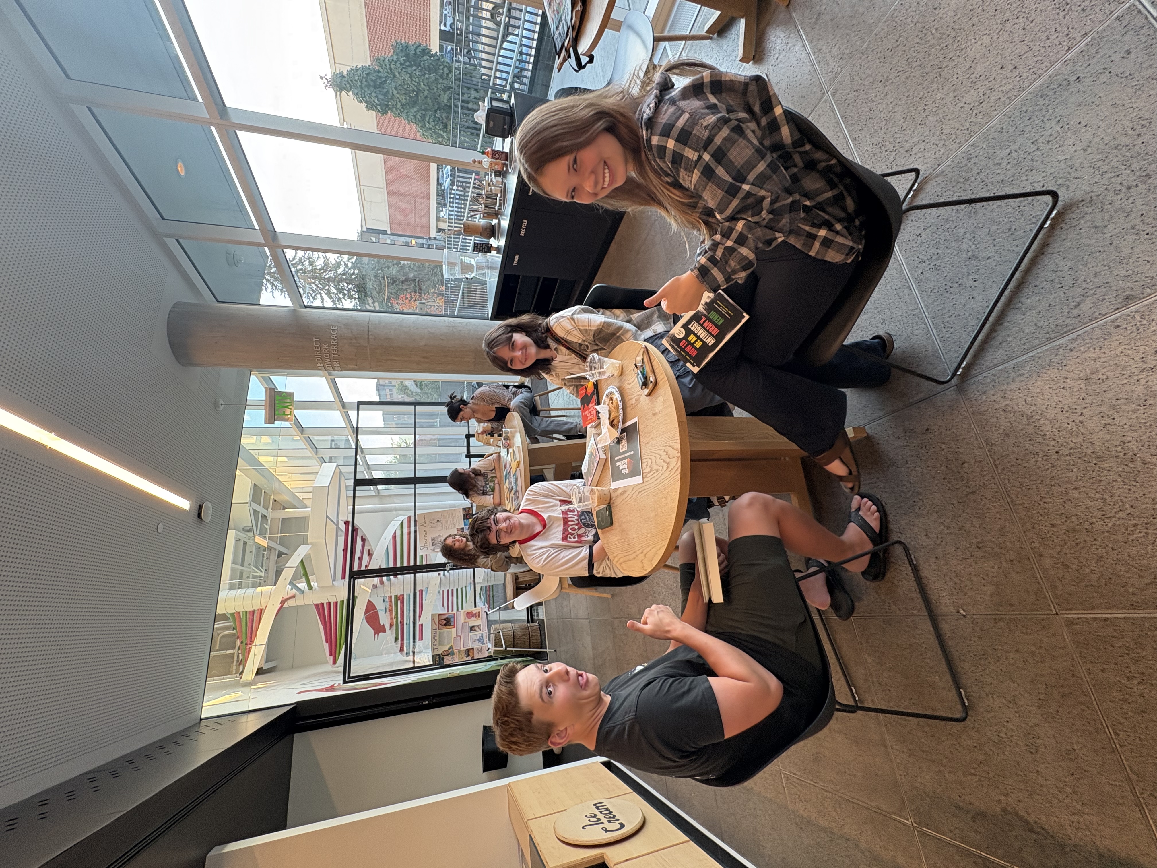 a group of students sitting at a table in the library