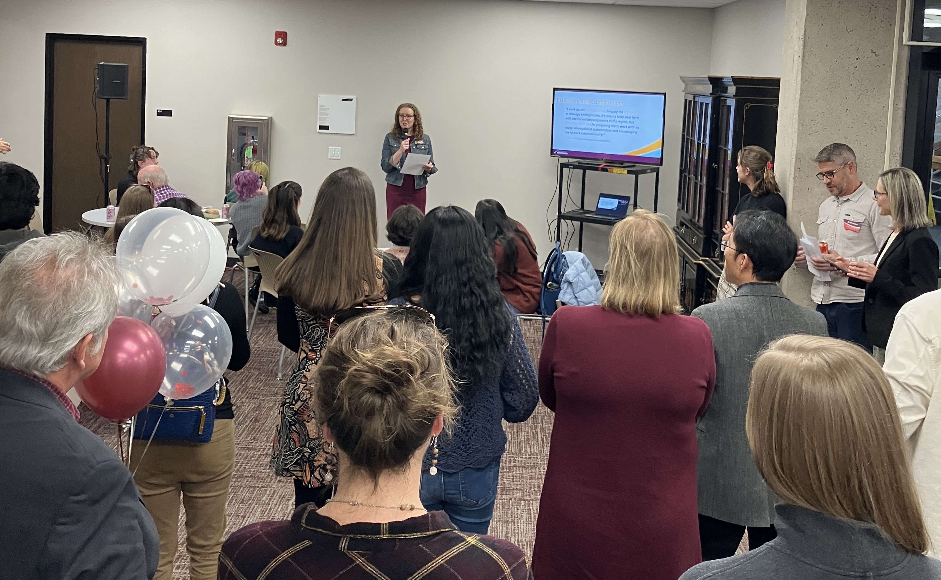 GLI Director Gillian Glaes delivers opening remarks in front of a large group of people.