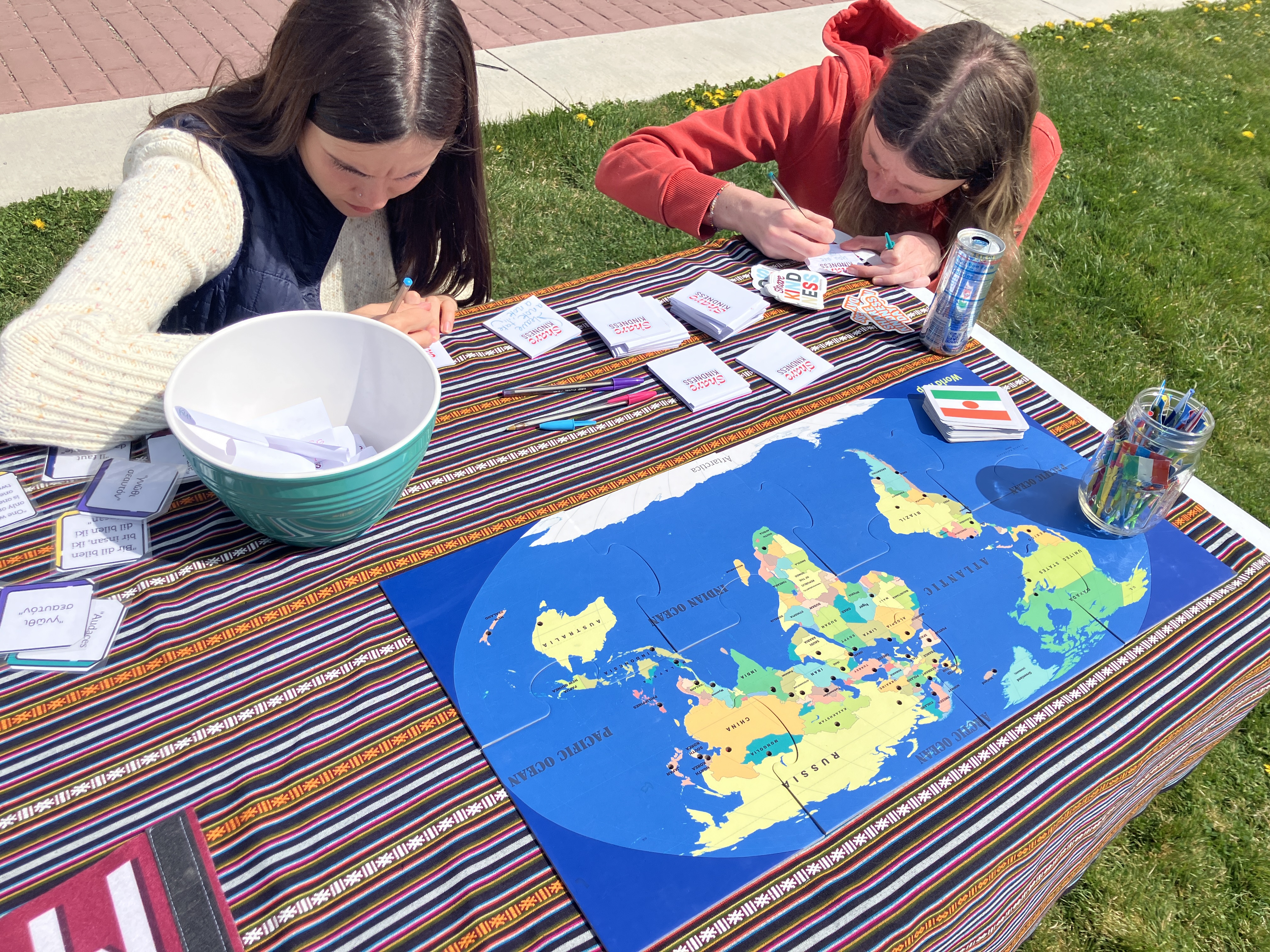 two students write kind notes to share with strangers for share kindness day activity