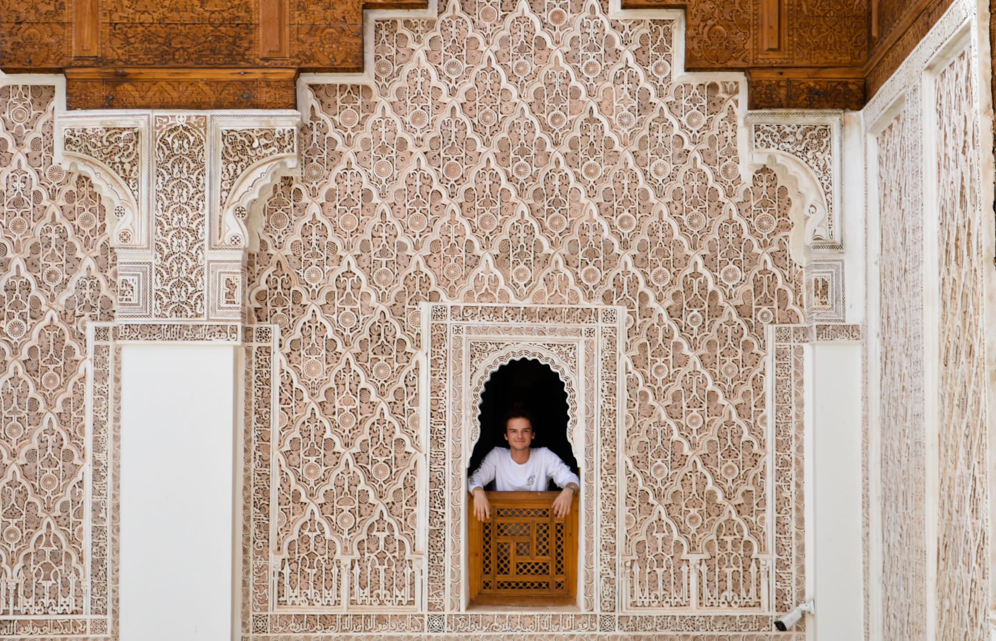 A student smiles from a window in Morocco
