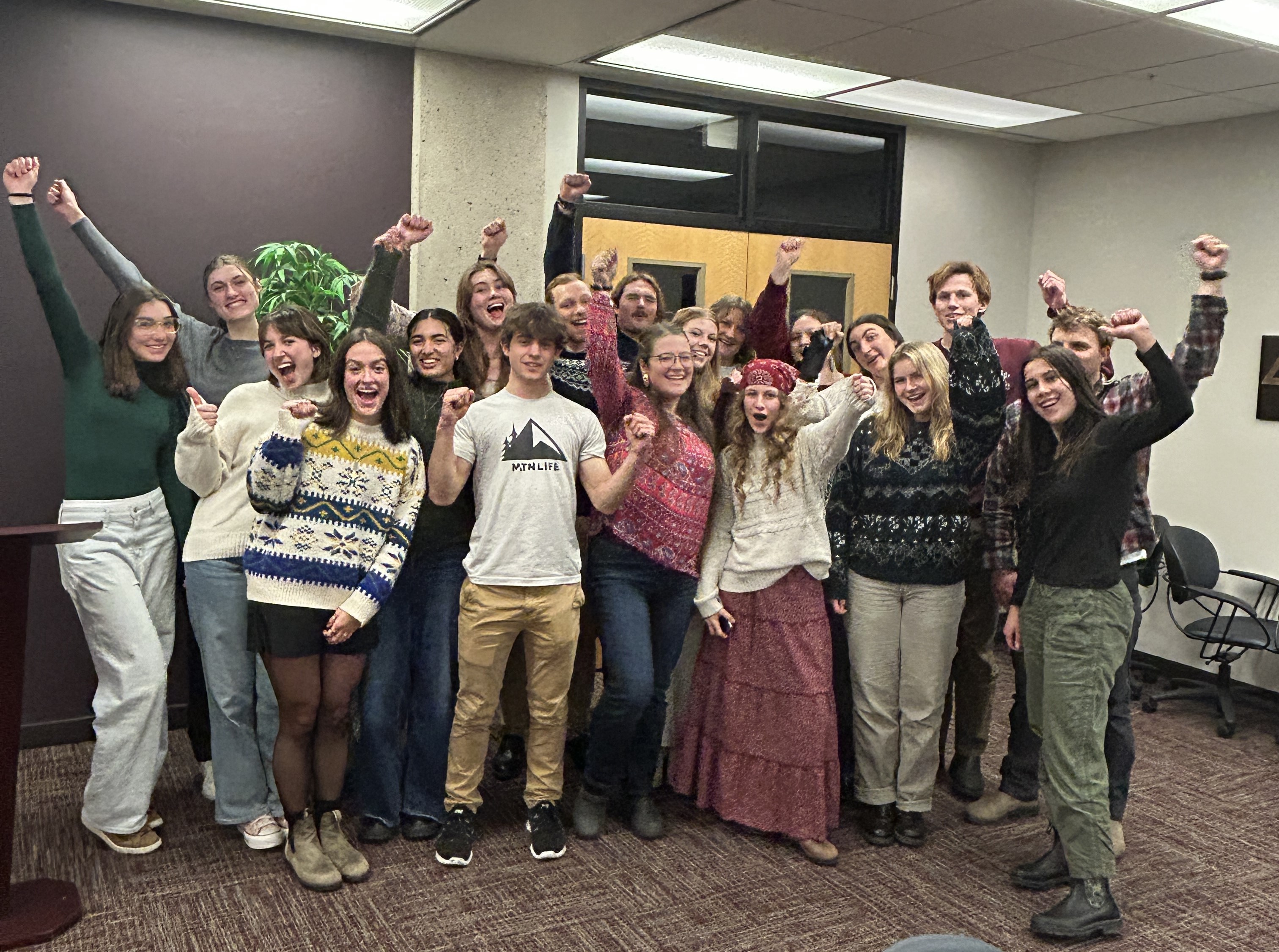 a group of 20 GLI students raise their hands in celebration