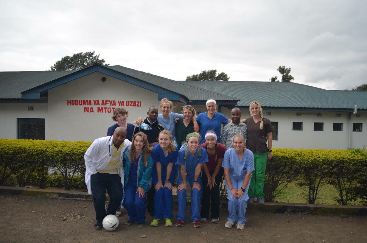 group of doctors and nursing standing outside clinic in Tanzania