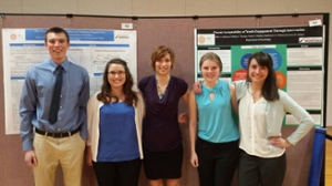 Four undergraduate research assistants stand in front of their research poster at the University of Montana Conference for Undergraduate Research
