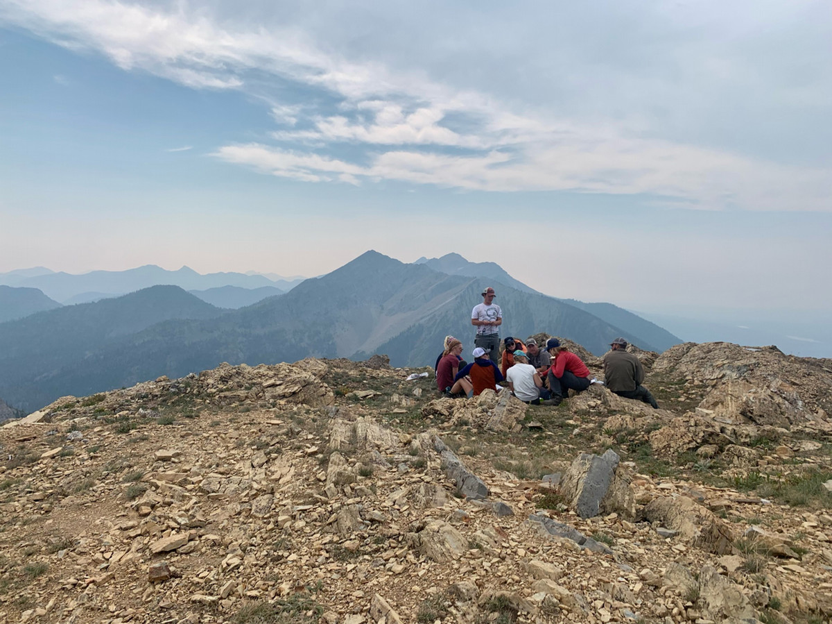 SVC students on a rocky mountain top in discussion.
